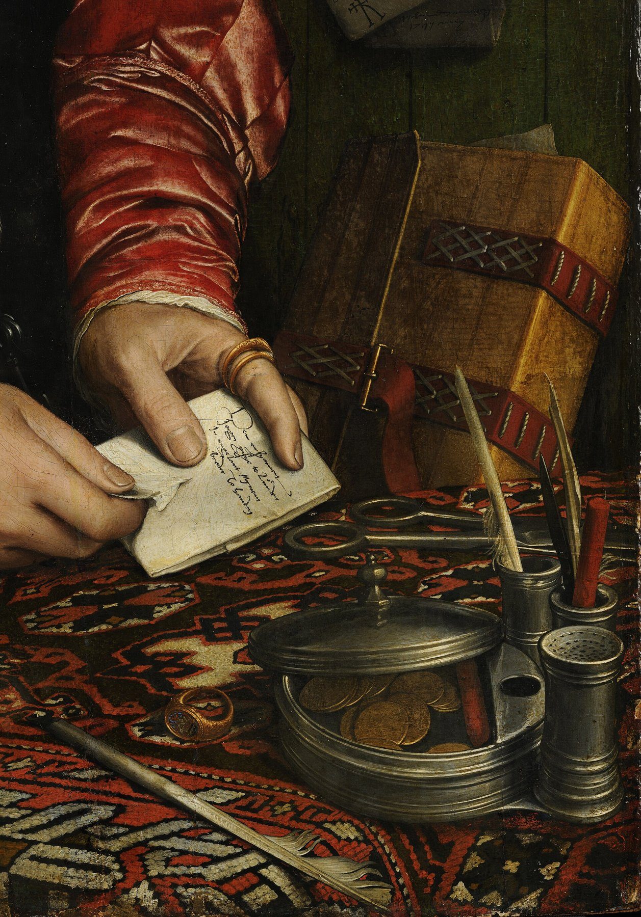 Detail of a Holbein painting: a merchant's hand holding a small folded letter, with a pewter inkwell and seals on a Turkish carpet